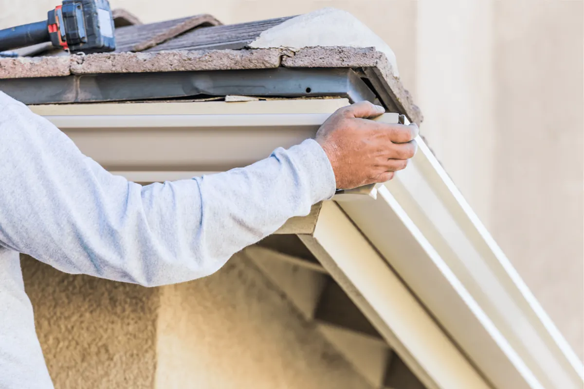 Old sagging gutters being replaced with new seamless aluminum on a mid-century Hampton, VA home